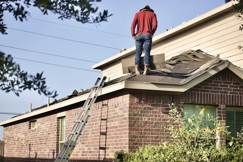 Professional roofer working on a residential roof in Viola